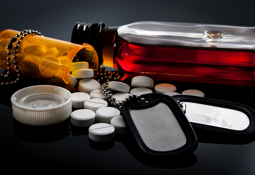 prescription medicine, alcohol, and dog tags, a concept image for how military service can lead to addiction and why military insurance coverage for drug addiction treatment is necessary