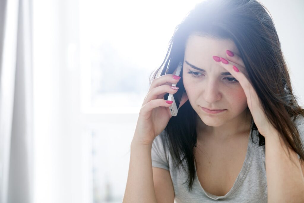 A concerned parent on the phone verifying health insurance coverage