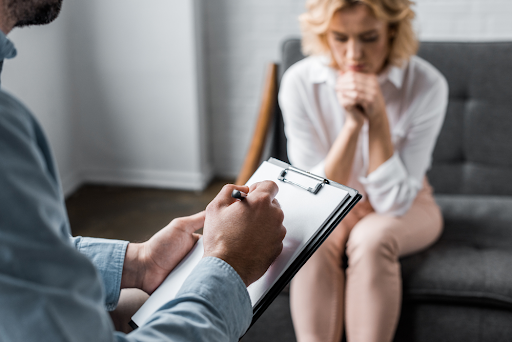 A woman speaking with a professional about addiction treatment costs and if her MultiPlan health insurance plan includes alcohol rehab coverage