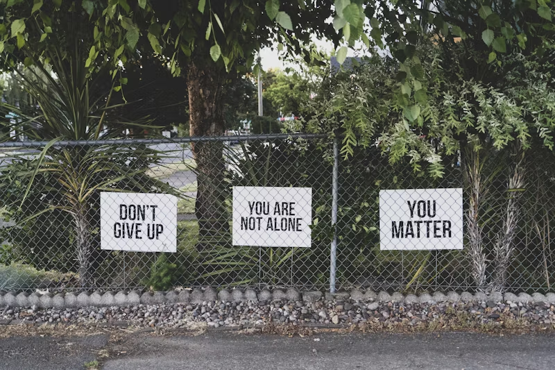 Evernorth Cigna mental health rehab coverage: Image of chainlink fence with uplifting messages on white placards.