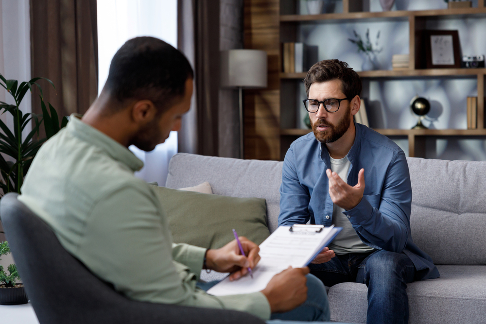 young man asking a counselor about his compsych mental health rehab coverage for treatment